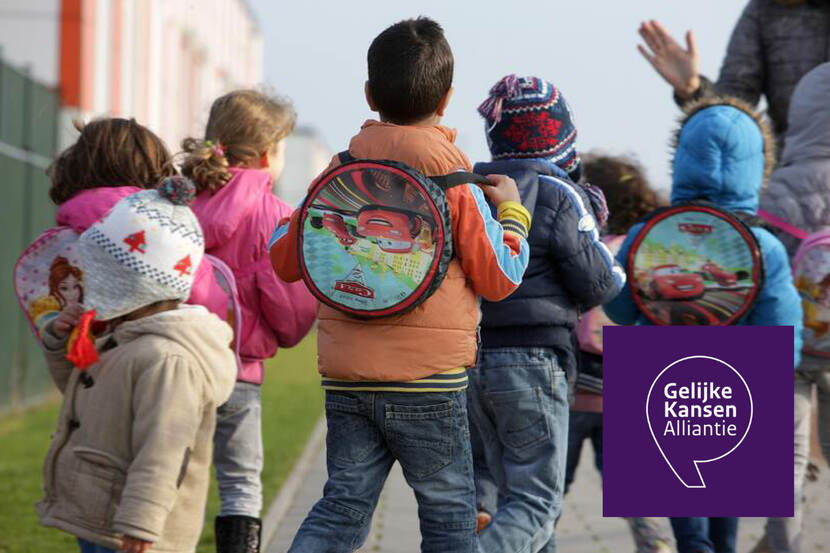 Schoolkinderen lopen met rugzak achter juf aan op straat
