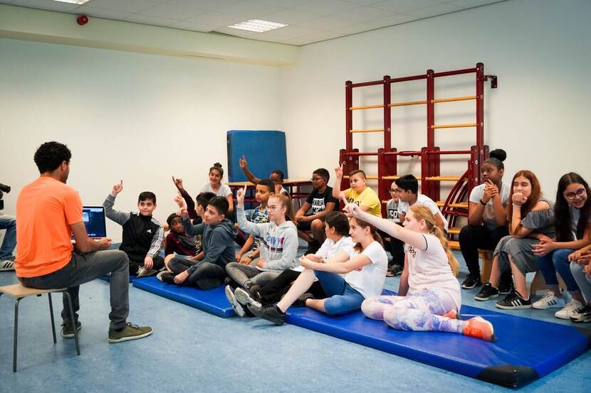 Soufiane Touzani geeft gastles aan plus minus 20 kinderen in een gymzaal